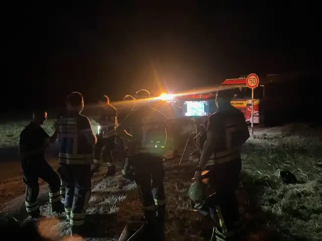 Feuerwehrleute bereiten nachts einen Drohneneinsatz beim Vegetationsbrand in Dortmund-Lanstrop vor