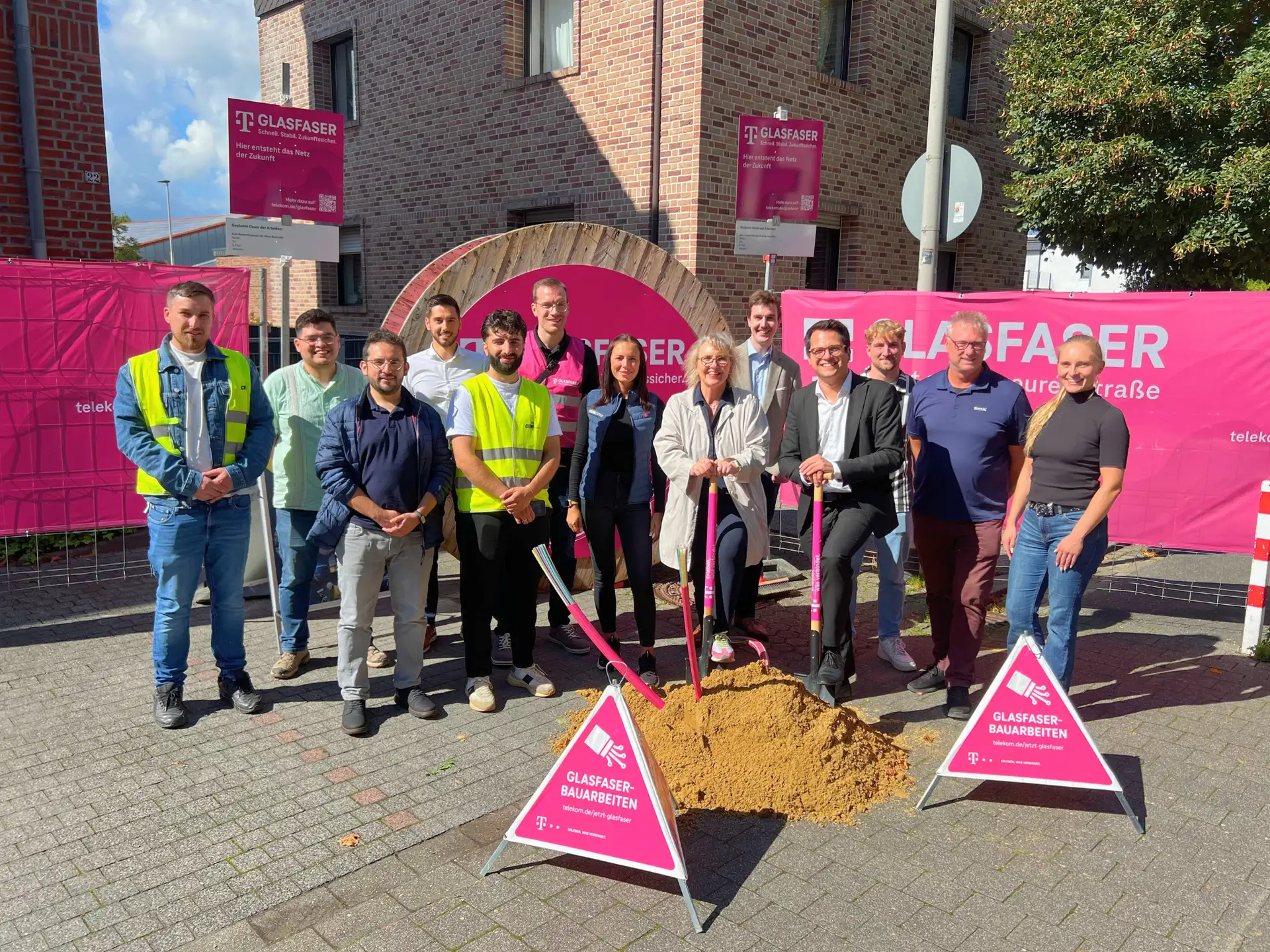 Gruppenfoto zum Spatenstich für den Glasfaserausbau der Telekom in Herzogenrath-Kohlscheid mit Vertretern der Stadt Herzogenrath, der Städteregion Aachen, der Telekom und Baufirmen.