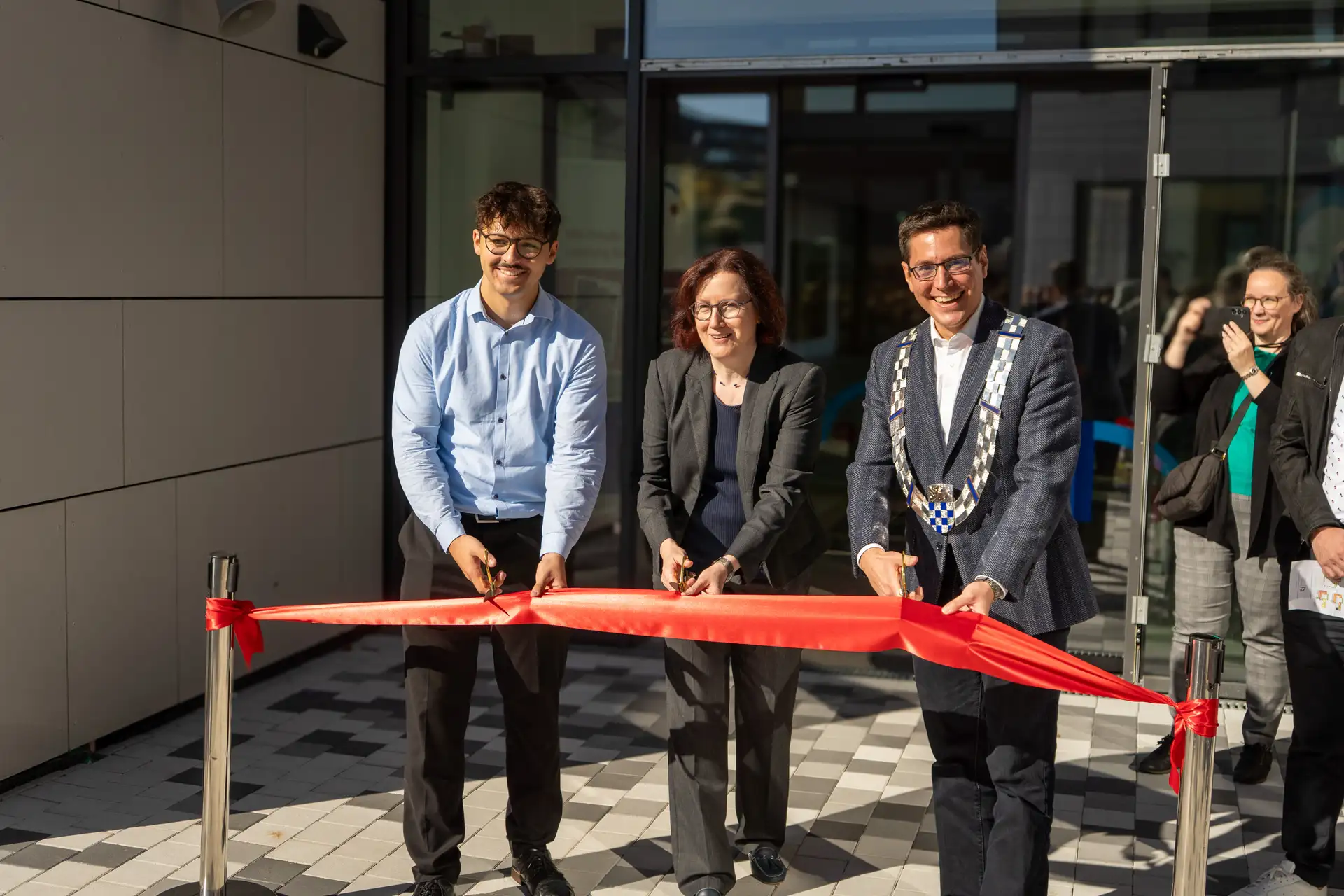 V.l.n.r. Schülersprecher Frederik Skora, Schulleiterin Birgit Fels und Bürgermeister Dr. Max Leitterstorf durchschneiden das Band und geben den neuen Erweiterungsbau am Rhein-Sieg-Gymnasium offiziell zur Benutzung frei.