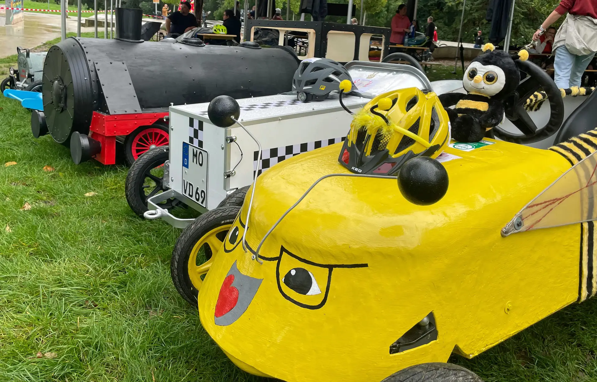 Seifenkistenrennen beim Speed-Cup, bei dem mehrere Rennkisten mit Teilnehmenden auf der Strecke fahren.