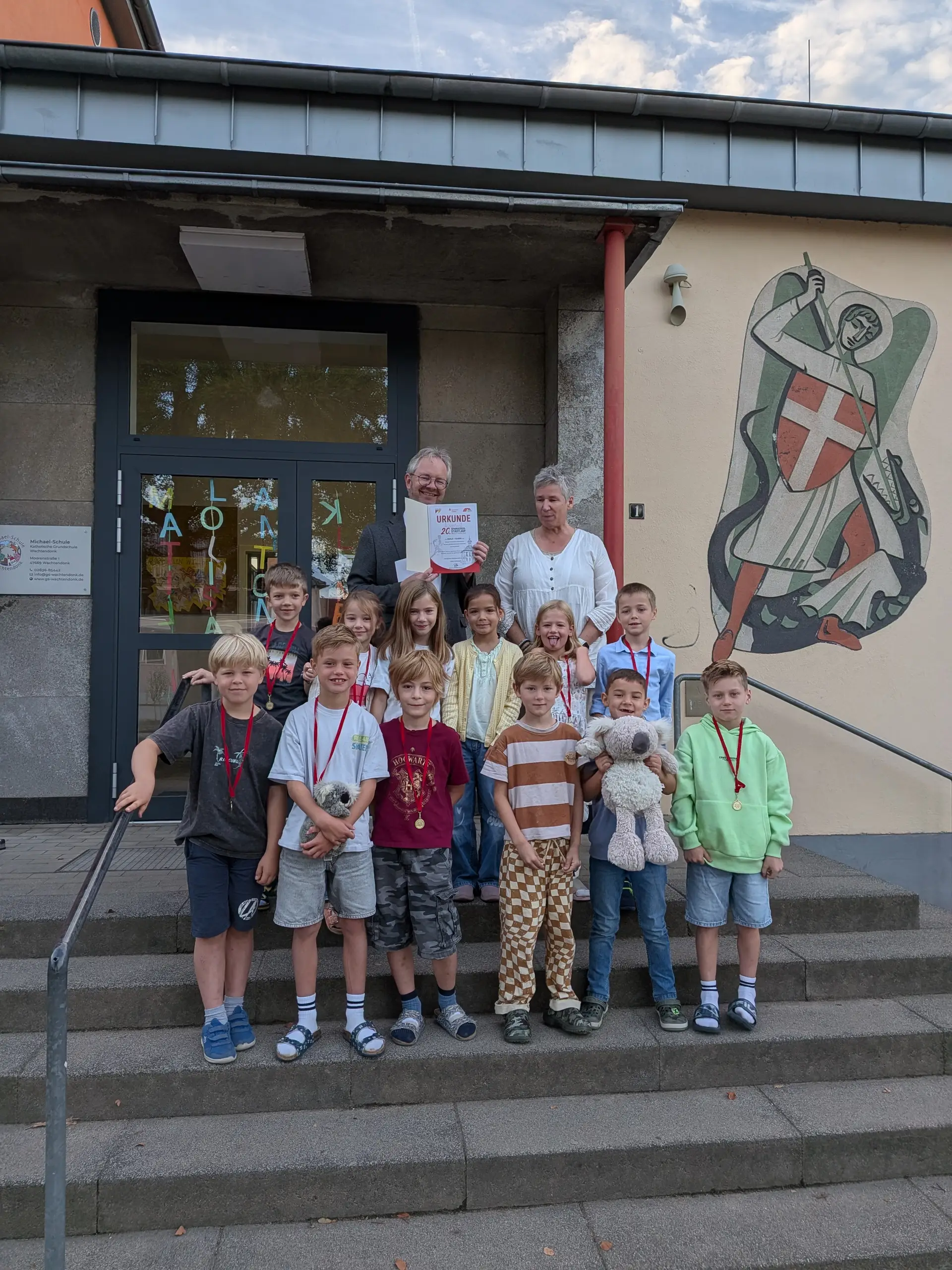 Personen überreichen Urkunden und Preise im Rahmen einer Veranstaltung; im Bild sind mehrere Teilnehmende vor einem Publikum zu sehen.